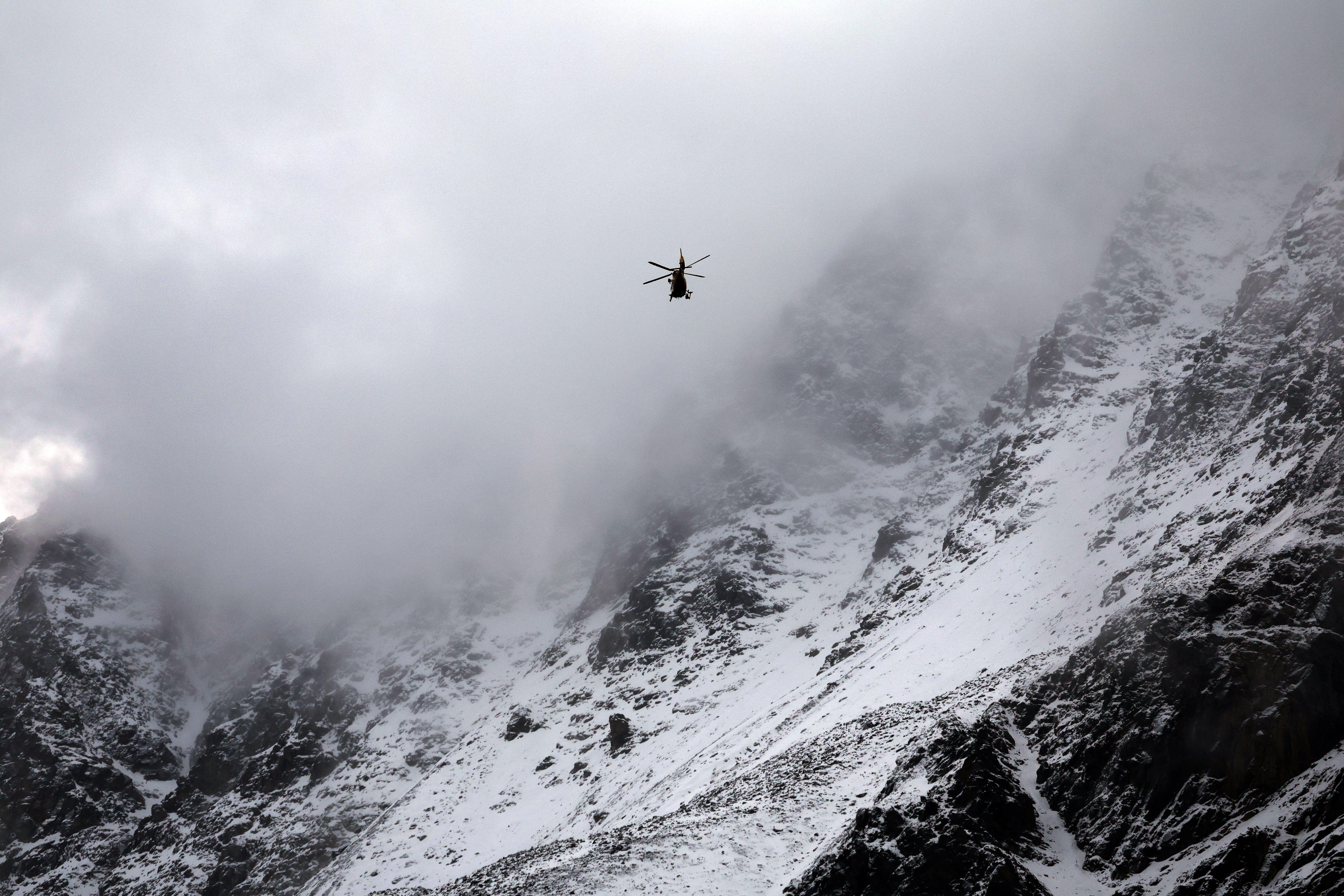 Ein Hubschrauber der Bergrettung fliegt auf der Suche nach zwei vermissten Bergsteigern vor dem mit Schnee bedeckten Ortler-Gebirge.