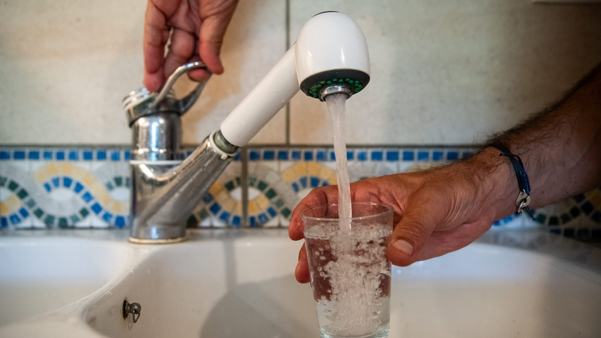 Symbolbild: Ein Mann füllt ein Glas Wasser auf | Bild: picture alliance / PHOTOPQR/LE BIEN PUBLIC/MAXPPP | Emma BUONCRISTIANI Symbolbild: Ein Mann füllt ein Glas Wasser auf
