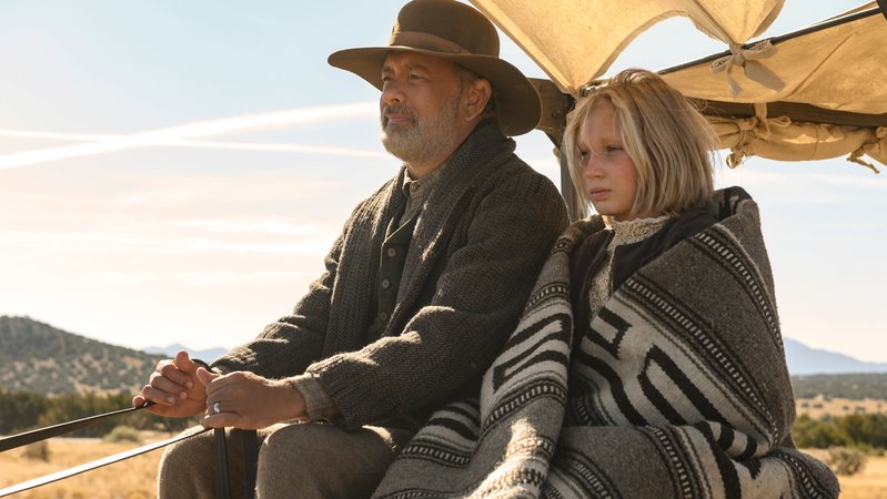Im Wilden Westen: Ein älterer Mann sitzt auf einer Pferdekutsche neben einem blonden Mädchen: Helena Zengel ("Systemsprenger") an der Seite von Tom Hanks in "Neues aus der Welt" (Filmszene).