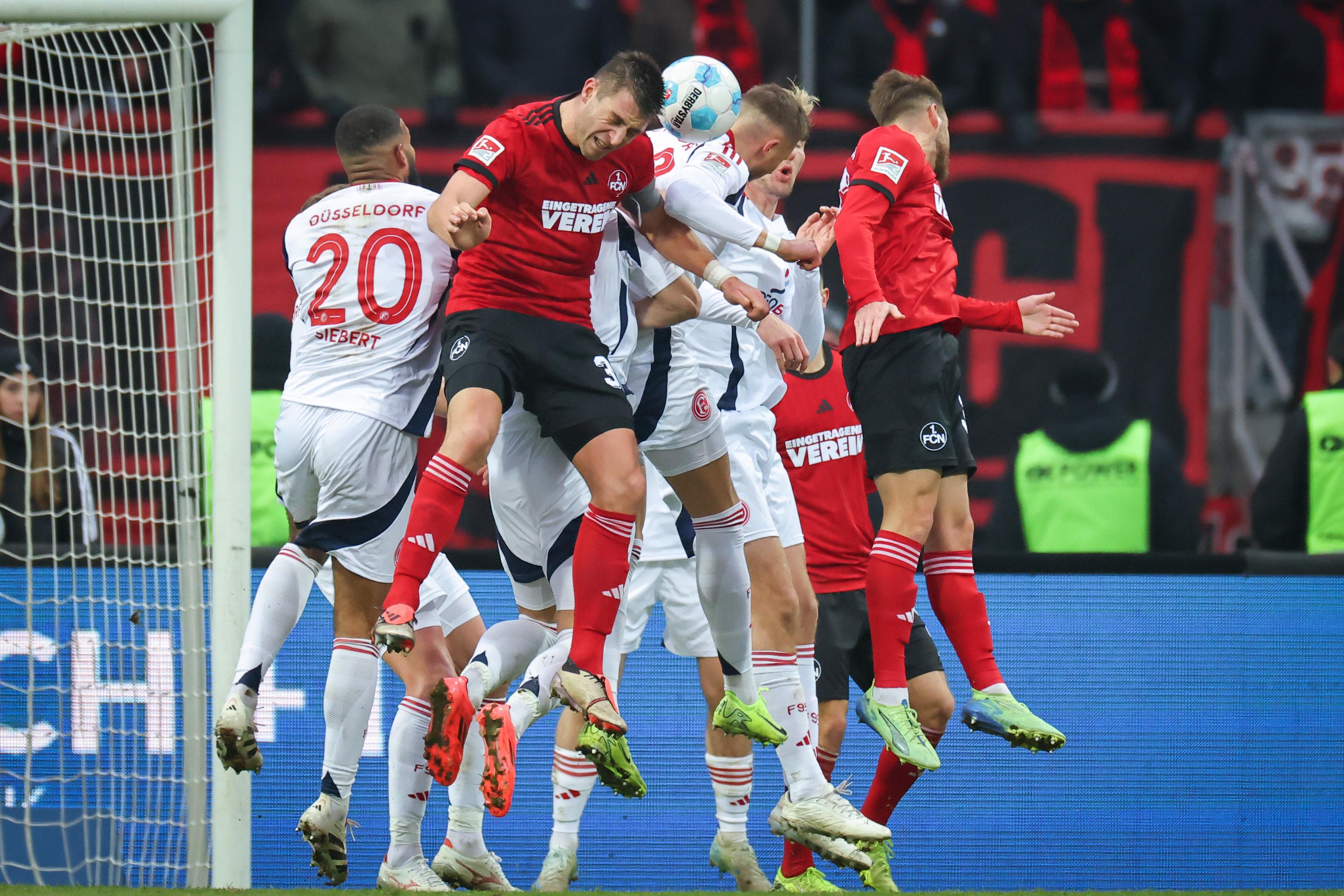 01.12.2024, Bayern, Nürnberg: Fußball: 2. Bundesliga, 1. FC Nürnberg - Fortuna Düsseldorf, 14. Spieltag im Max-Morlock-Stadion. Die Spieler beider Mannschaften kämpfen um den Ball vor dem Düsseldorfer Tor. 