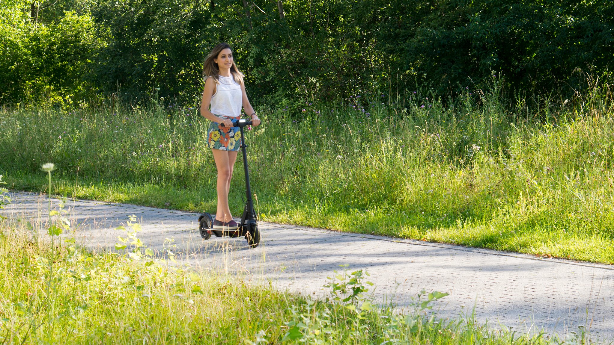 Die Doktorandin am Algentechnikum testet den E-Scooter, den sie aus Algen-Carbonfasern gebaut hat.