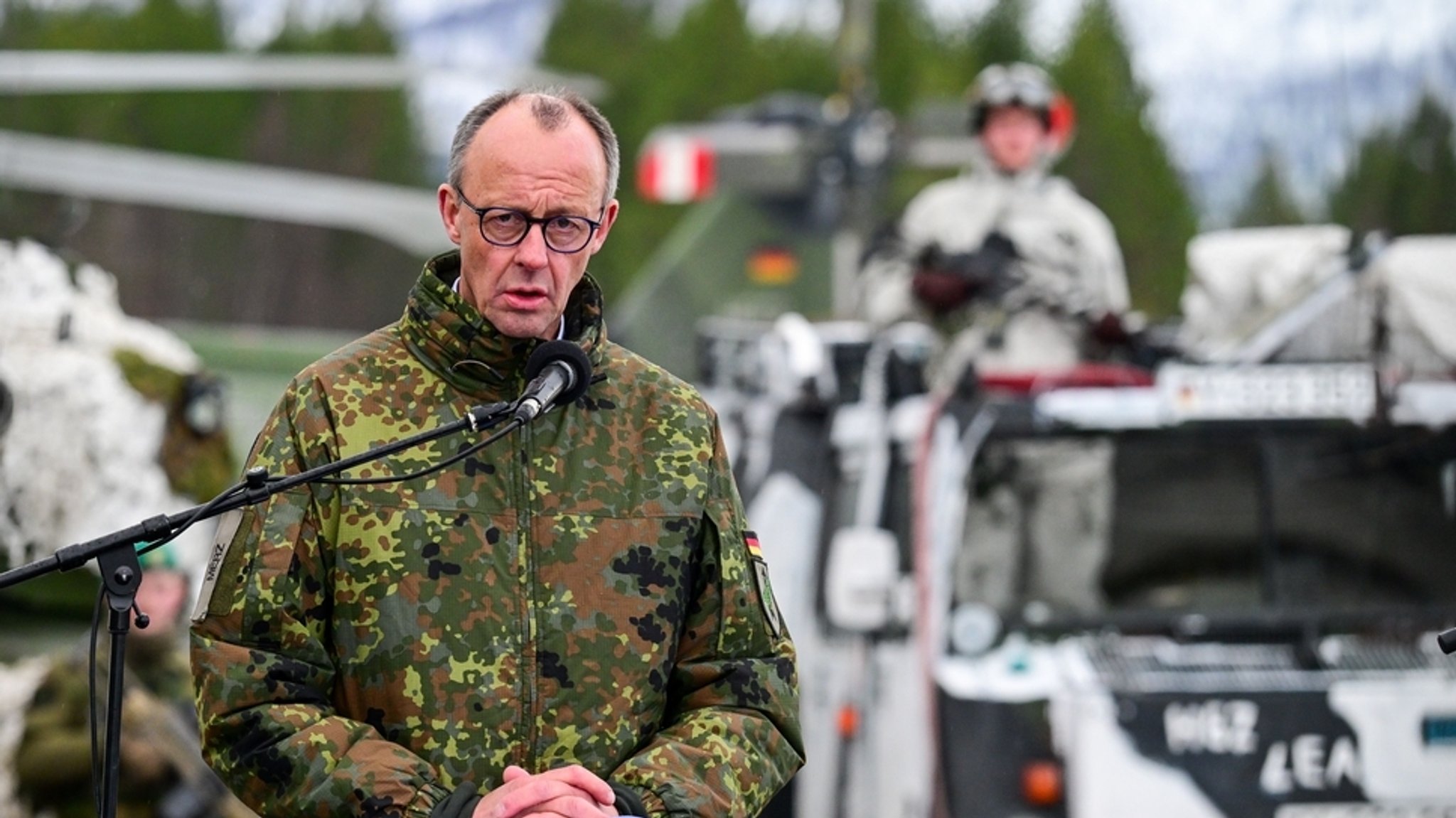 13.03.2026, Norwegen, Bardufoss: Bundeskanzler Friedrich Merz (CDU) steht auf dem Truppenübungsplatz nach der Nato-Übung «Cold Response», während einer gemeinsamen Pressekonferenz mit dem kanadischen Premierminister Carney und dem norwegischen Ministerpräsidenten Støre.