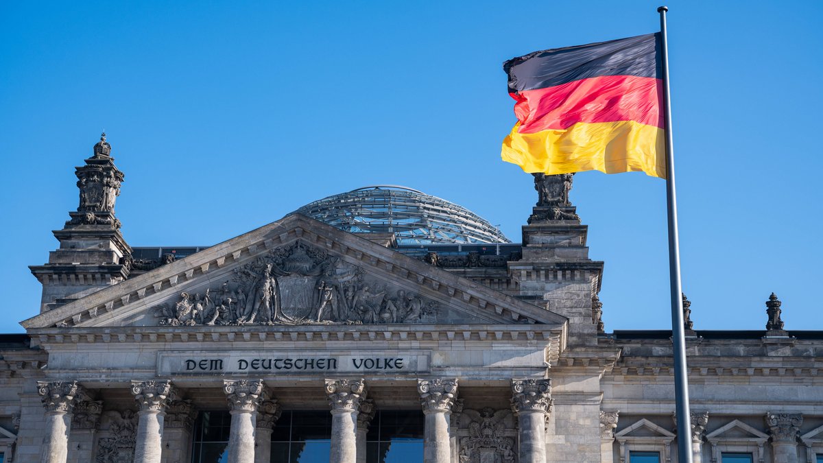 Eine Deutschlandfahne weht vor dem Reichstagsgebäude in Berlin