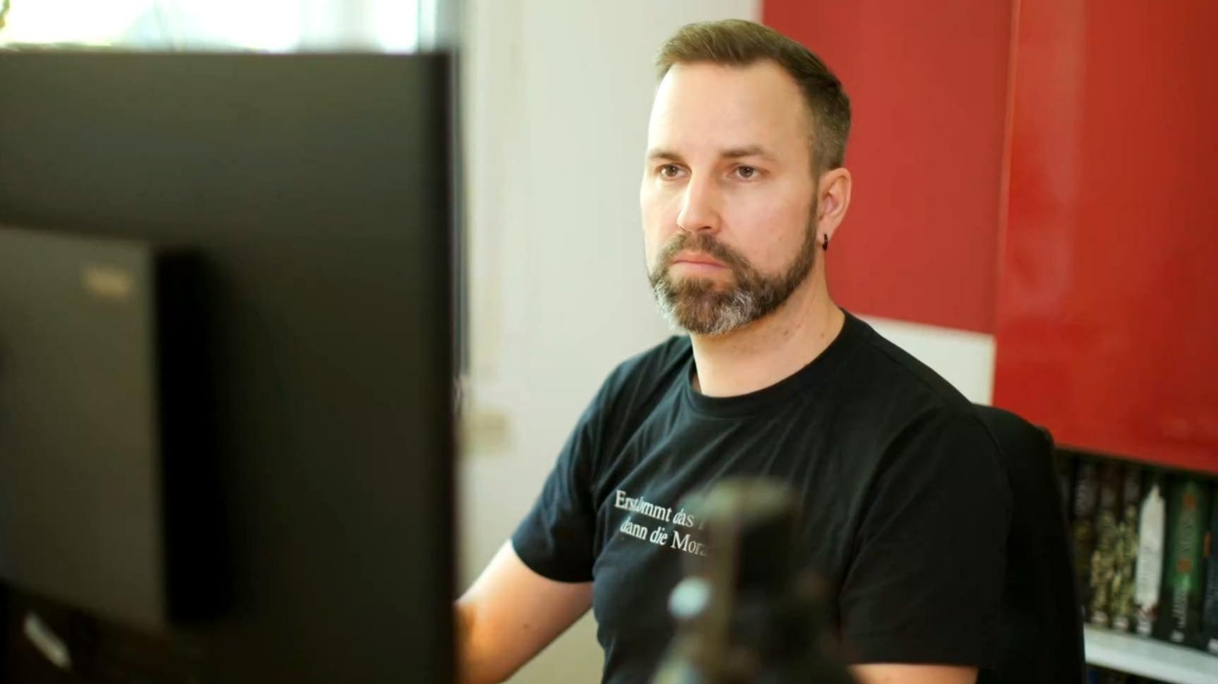 Arbeitender Mann vor einem Monitor.