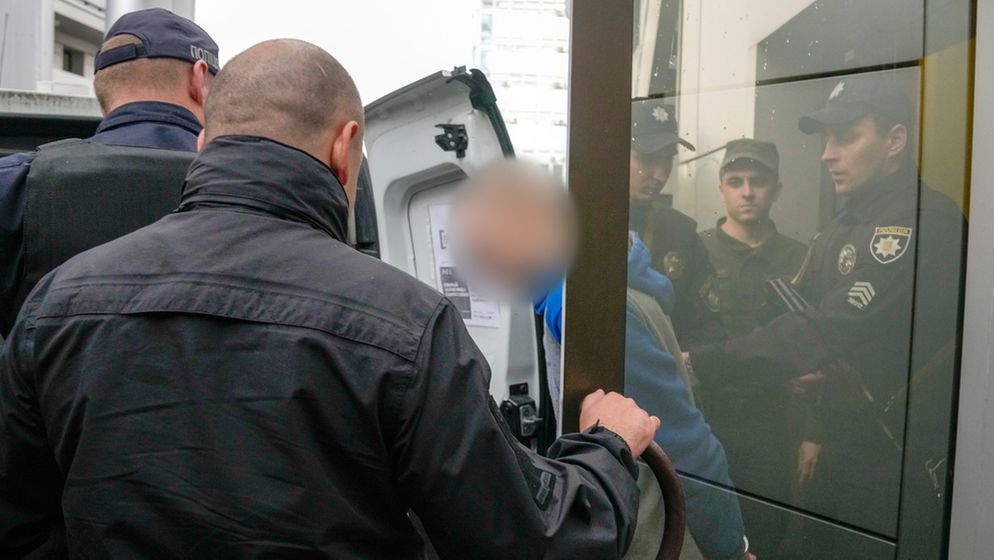 Der 21-Jährige russische Soldat wird von Polizisten nach der Gerichtsverhandlung in Kiev begleitet.  | Bild:Natacha Pisarenko/AP/dpa