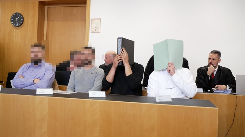 Die Angeklagten im Gerichtssaal des Augsburger Landgerichts. Hinter ihnen ihre Verteidiger.