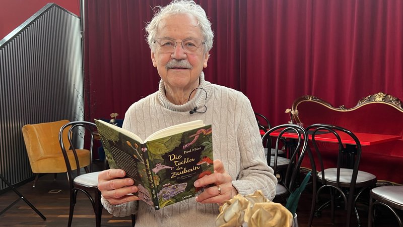 Paul Maar hält sein neues Buch "Die Tochter der Zauberin" in der Hand.  | Bild: BR/Sandra Jozipovic Paul Maar hält sein neues Buch "Die Tochter der Zauberin" in der Hand.
