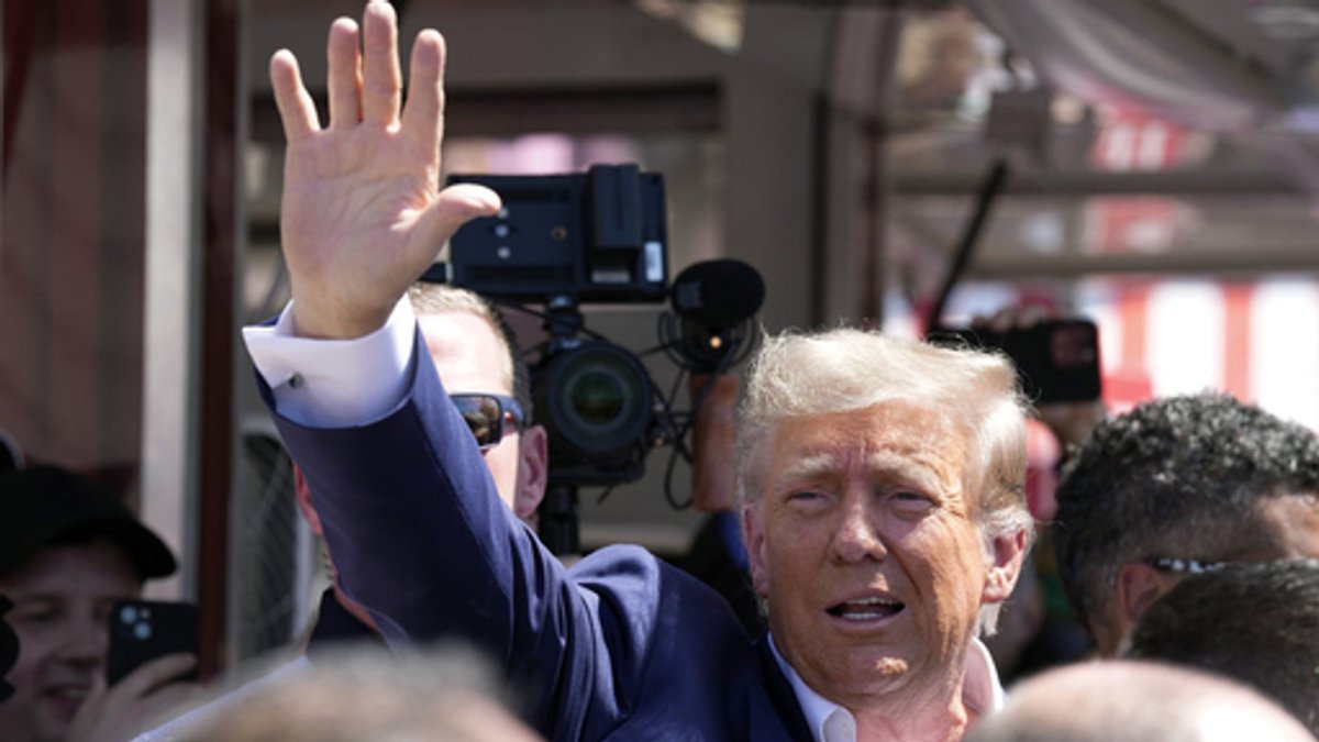 Ex-Präsident Donald Trump winkt seinen Anhängern bei einem Auftritt in Des Moines, Iowa am 12. August 2023 zu.