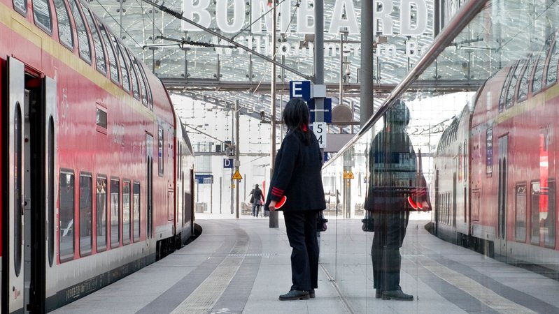 Eine Zugbegleiterin steht am Bahnhof. | Bild: picture alliance / dpa Themendienst | Franziska Gabbert Eine Zugbegleiterin steht am Bahnhof.