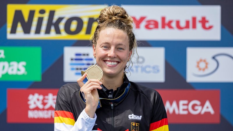 Japan, Fukuoka: Schwimmen: Weltmeisterschaft, Freiwasser, 10 km Frauen. Leonie Beck zeigt nach dem Sieg ihre Goldmedaille. 