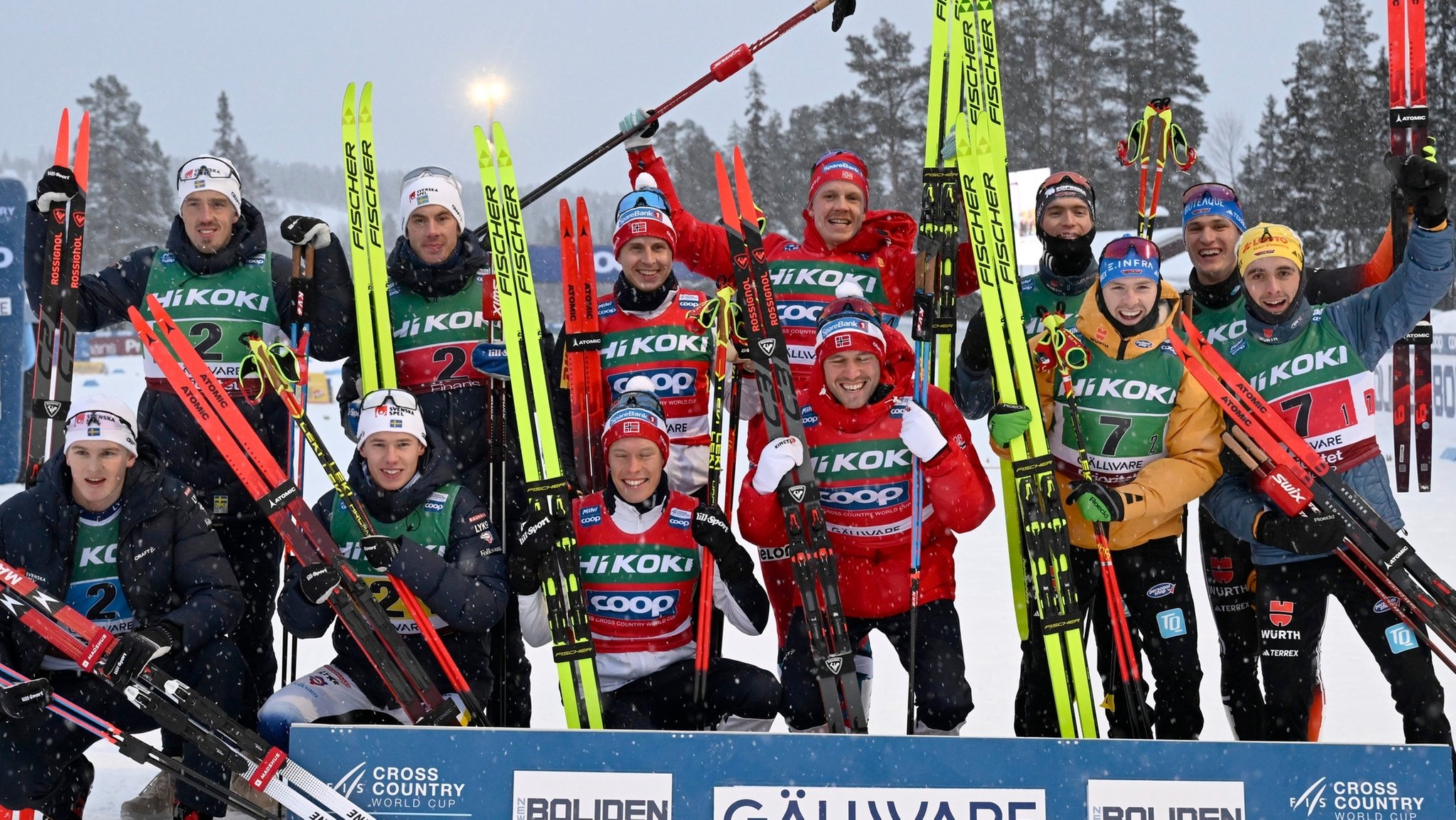 Staffel 4 x 7,5 km, Herren:  Team Schweden mit Johan Häggström (l-r), Calle Halfvarsson, Leo Johansson und Edvin Anger, die den zweiten Platz belegten, Team Norwegen mit Paal Golberg, Martin Loewstroem Nyenget, Simen Hegstad Krüger und Jan Thomas Jenssen, die den ersten Platz belegten, und Team Deutschland mit Janosch Brugger, Albert Kuchler, Friedrich Moch und Anian Sossau, die den dritten Platz belegten, lächeln nach dem Rennen . 