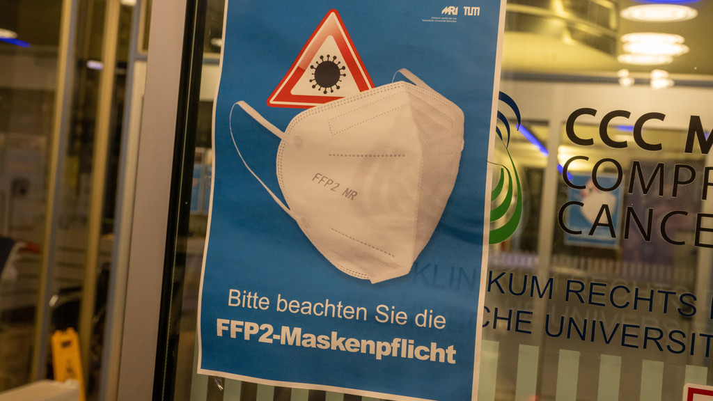 Ein Plakat mit der Aufschrift "Bitte beachten Sie die FFP2-Maskenpflicht" hängt am Eingang des Krankenhaus "Rechts der Isar".