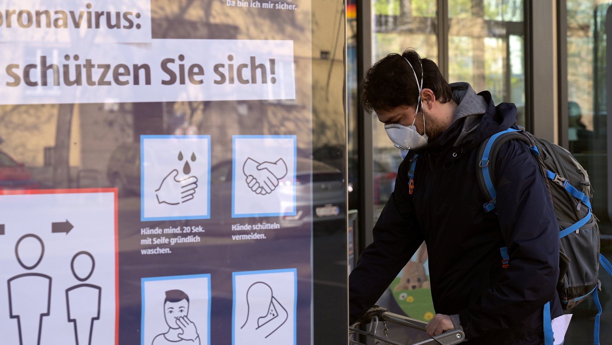 Ein Mann mit Maske vor einem Supermarkt