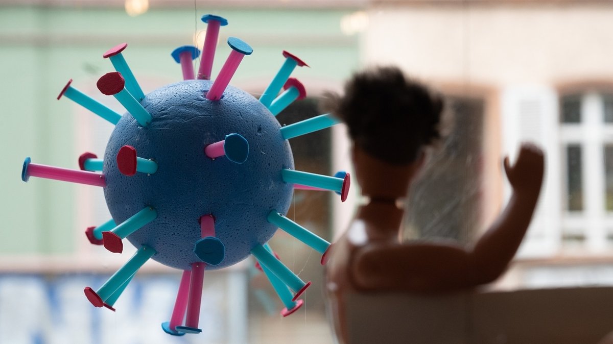 Ein stilisiertes Corona-Virus hängt in einem Schaufenster.
