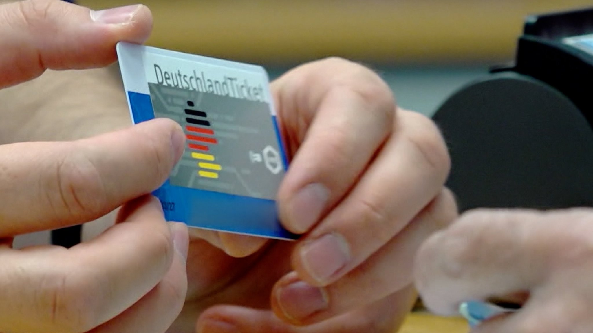 Eine Person hält ein Deutschlandticket in den Händen.