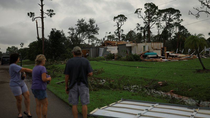 Menschen schauen auf zerstörte Häuser in Lakewood Park, nahe Fort Pierce, in St. Lucie County, Florida | Bild: REUTERS/Jose Luis Gonzalez Menschen schauen auf zerstörte Häuser in Lakewood Park, nahe Fort Pierce, in St. Lucie County, Florida