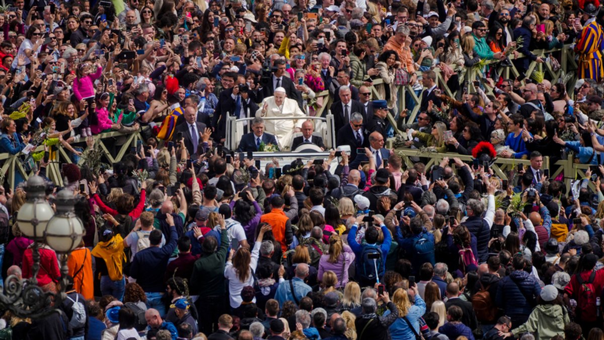 Papst Franziskus (M) fährt auf dem Papamobil an den Gläubigen vorbei als er die Palmsonntagsmesse verlässt.