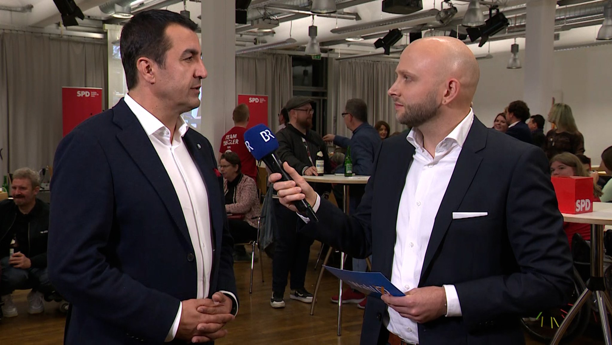 Arif Taşdelen (links) im Gespräch mit BR-Reporter Jonas Miller (rechts).