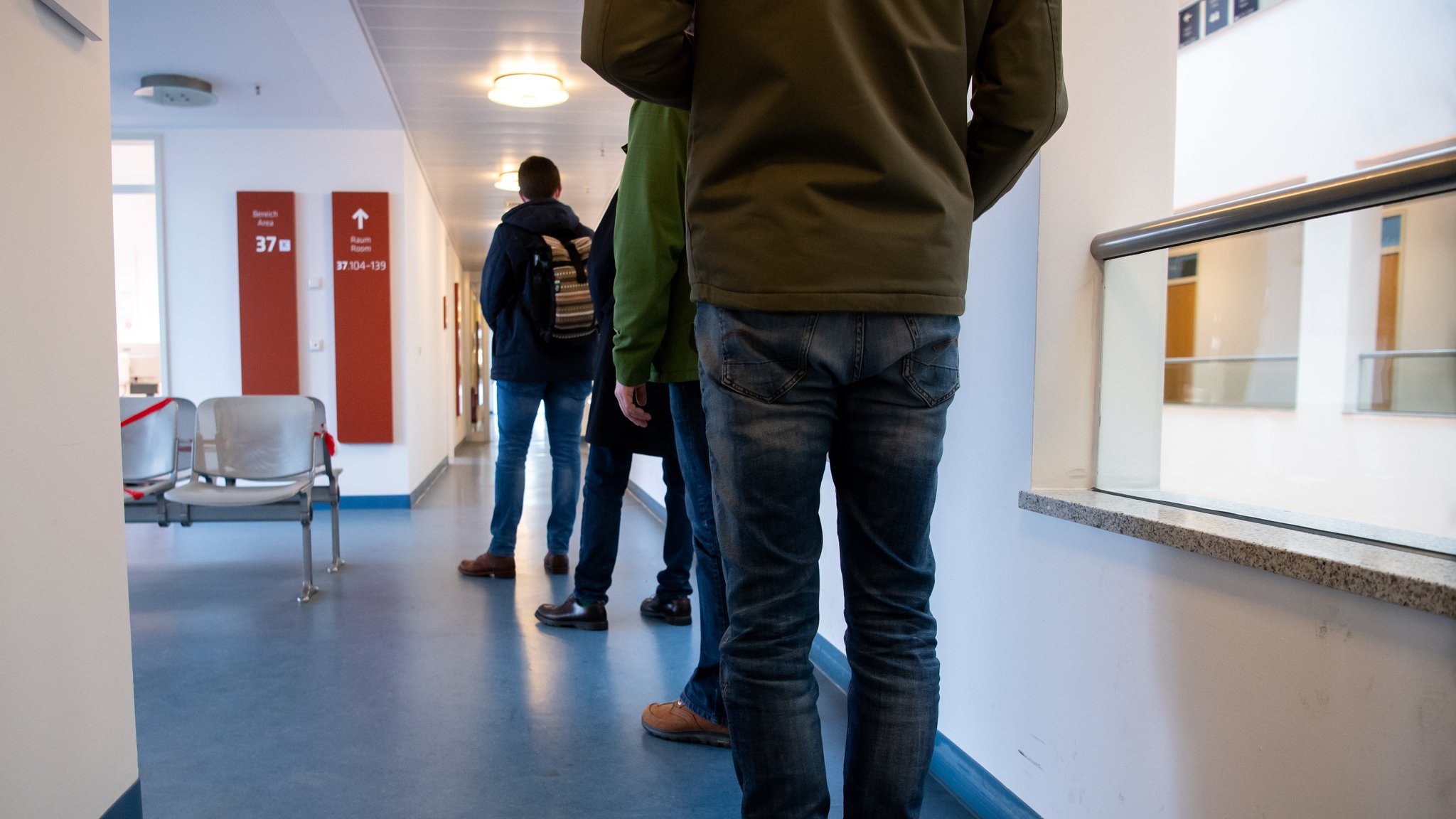 Menschen warten im Standesamt München vor einem Büro um ihren Kirchenaustritt zu beantragen.