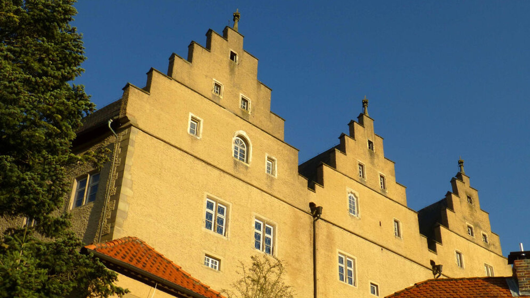 Drei markante Giebel und ein trutziger Bergfried: Weithin sichtbar dominiert Schloss Mainberg das Maintal bei Schweinfurt.