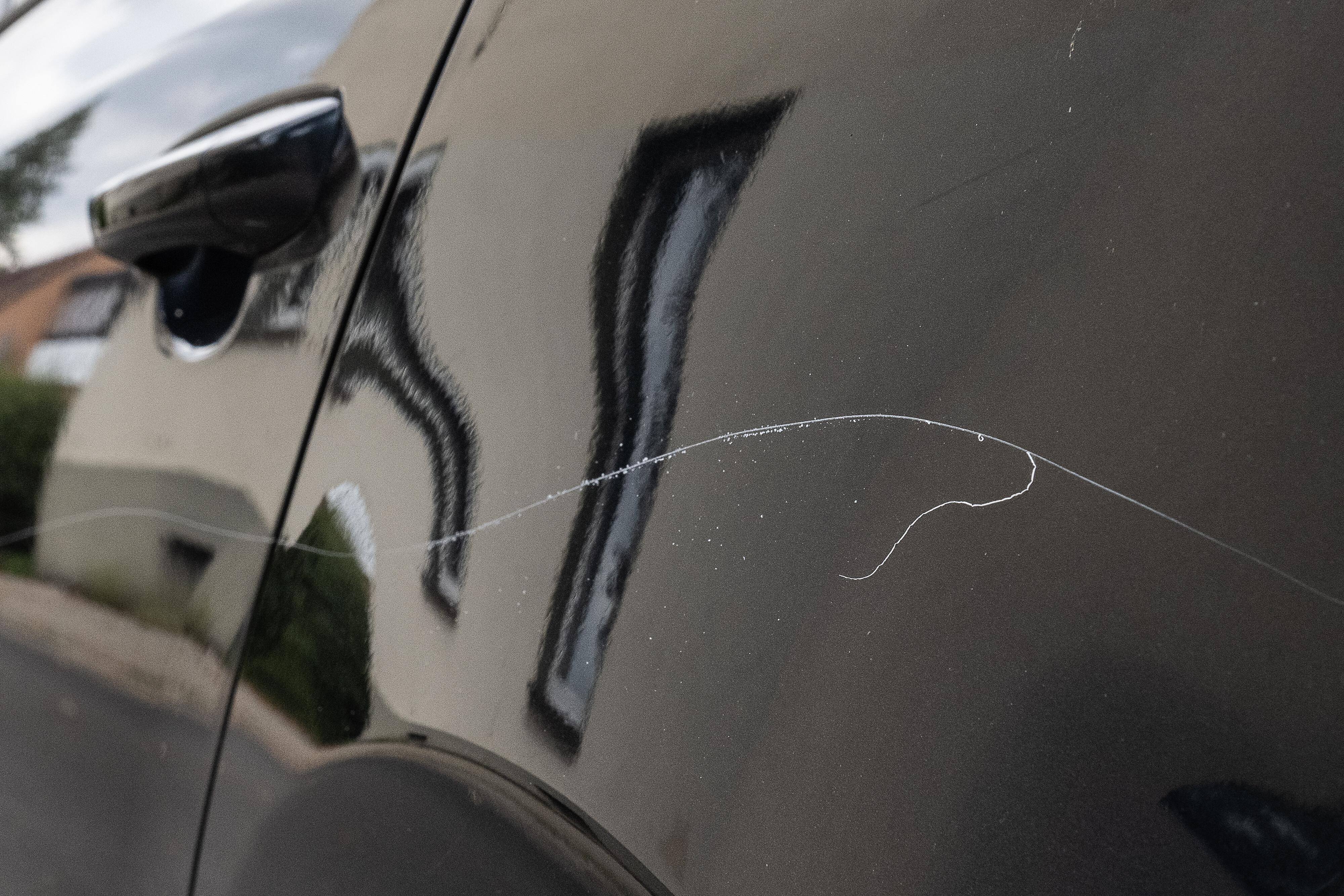 (Symbolbild) Ein Lackkratzer ist an einem parkenden Fahrzeug.