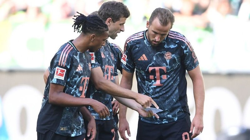 Michael Olise, Thomas Müller und Harry Kane studieren die Anweisungen ihres Trainers. | Bild: Bildrechte: dpa-Bildfunk/Swen Pförtner Michael Olise, Thomas Müller und Harry Kane studieren die Anweisungen ihres Trainers.