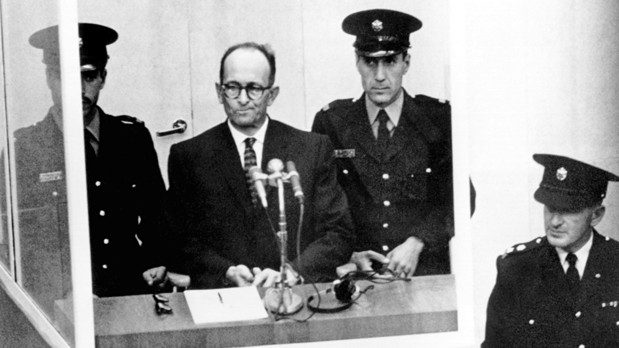 NS-Kriegsverbrecher Adolf Eichmann (2.v.l) steht während seiner Vernehmung am ersten Prozesstag vor dem Bezirksgericht in Jerusalem.