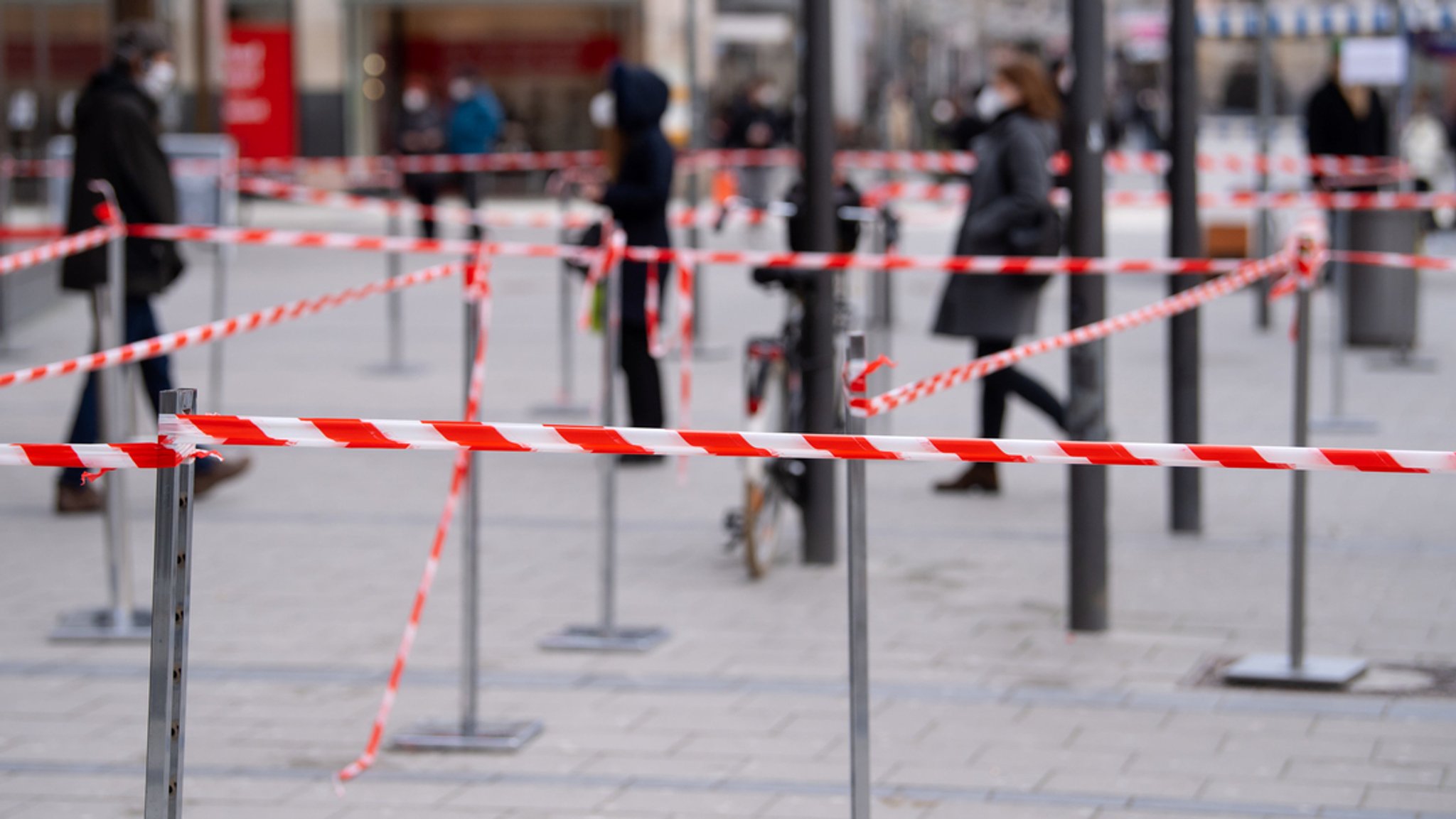 Bayern, München: Einkäufer warten vor einem Geschäft in der Innenstadt in einer Warteschlange.