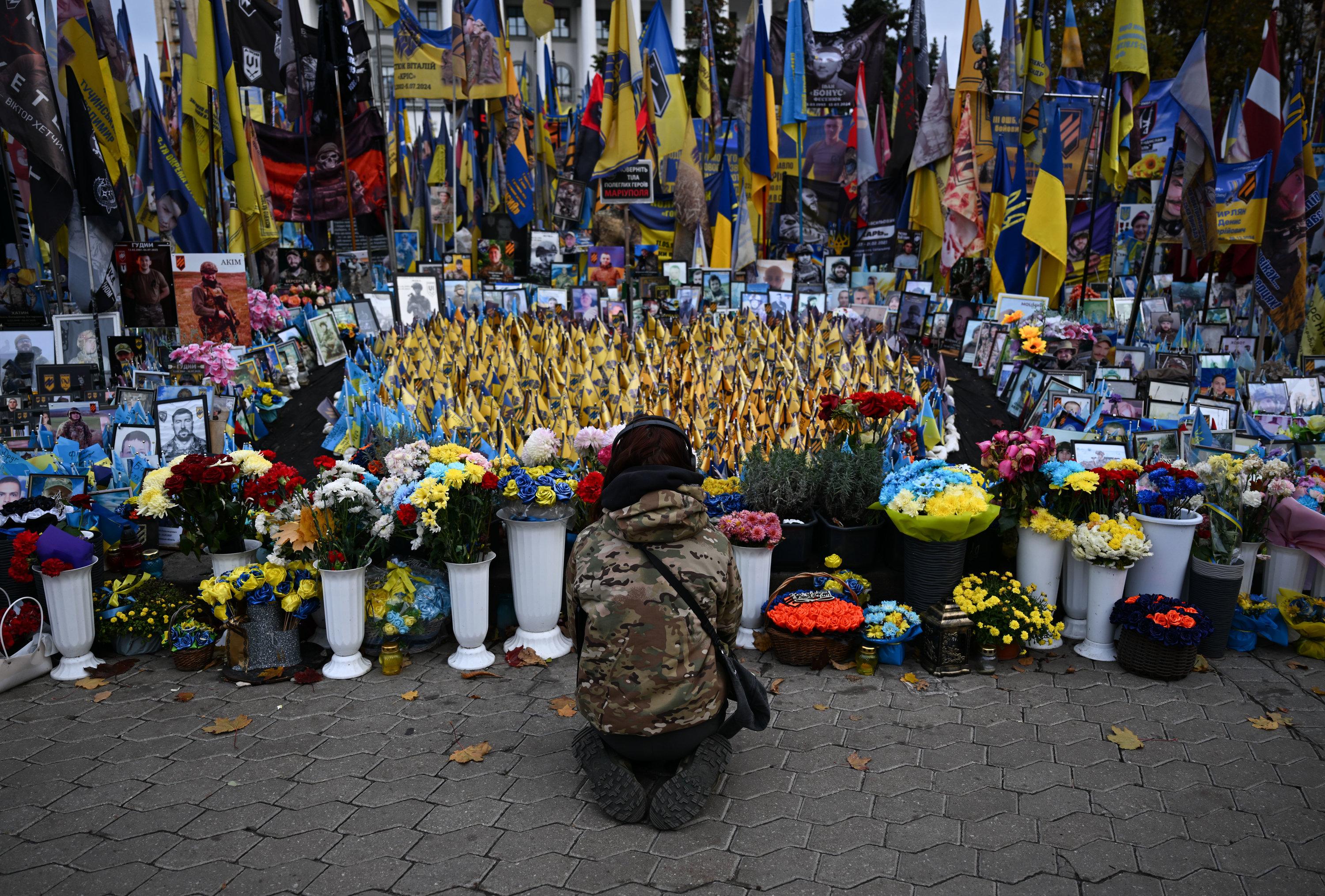 dpatopbilder - 30.10.2025, Ukraine, Kiew: Eine junge Frau kniet am Unabhängigkeitsplatz Maidan in Kiew. Hier wird den Gefallenen des Krieges gedacht. Die Bundesministerin für wirtschaftliche Zusammenarbeit und Entwicklung,  Alabali Radovan, besucht am selben Tag die Ukraine. Sie informiert sich über Zivilschutz im Krieg und Hilfen für die Bevölkerung. Foto: Hendrik Schmidt/dpa +++ dpa-Bildfunk +++