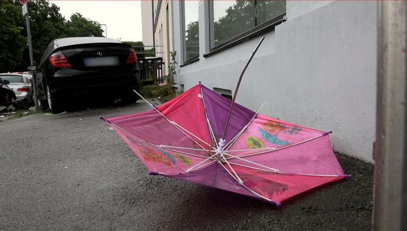 Ein Kinder-Regenschirm liegt auf der Straße | Bild: BR Ein Kinder-Regenschirm liegt auf der Straße