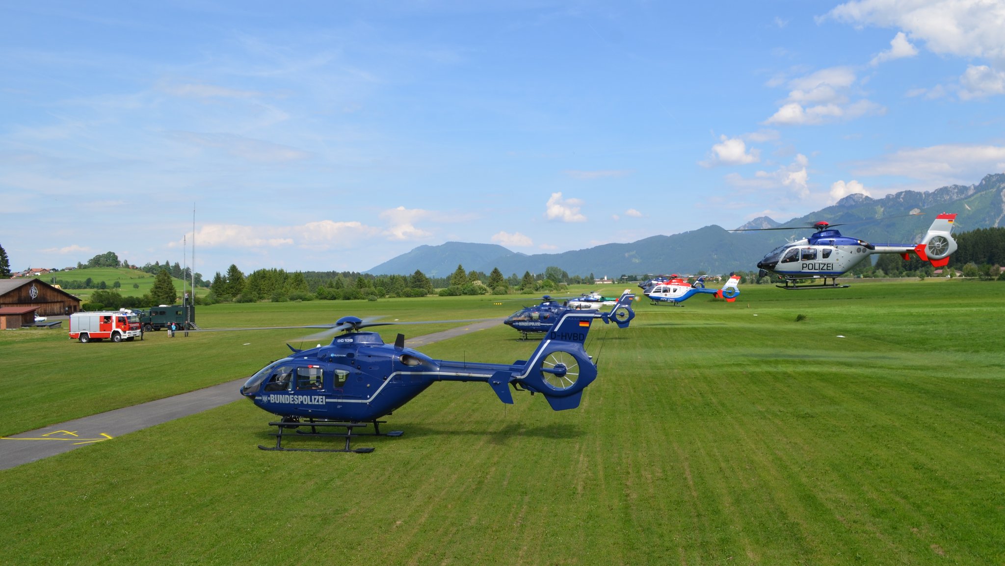 Polizeihubschrauber eines Ausbildungslehrgangs am Start- und Landeplatz, im Hintergrund Berge