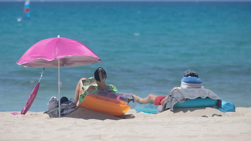 Bei besonders hohen Temperaturen im Mittelmeer, eine Folge des Klimawandels mit Auswirkungen auch auf das Wetter bei uns: Menschen sonnen sich am Strand von Arenal auf Mallorca. | Bild: Clara Margais/dpa-Bildfunk Bei besonders hohen Temperaturen im Mittelmeer, eine Folge des Klimawandels mit Auswirkungen auch auf das Wetter bei uns: Menschen sonnen sich am Strand von Arenal auf Mallorca.