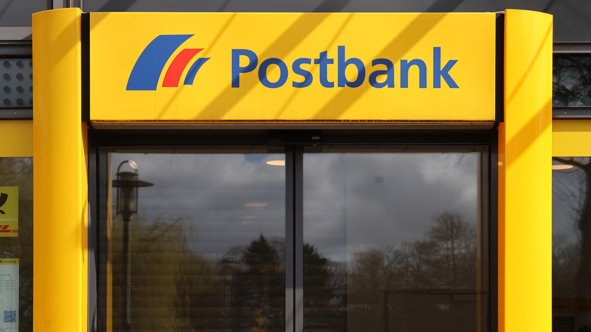 (Symbolbild) Blick auf den Eingang einer Postbank-Filiale