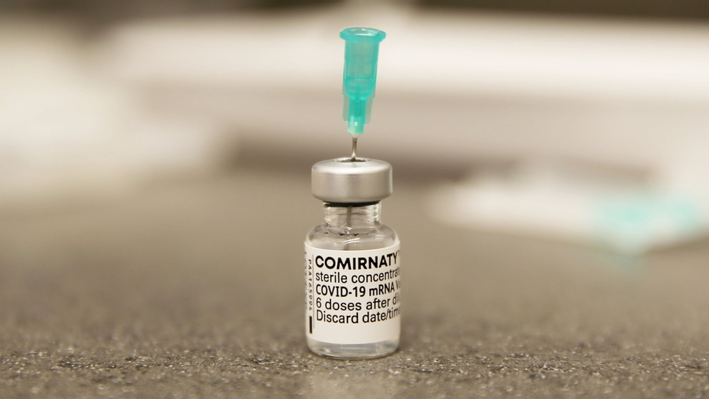 Eine Nadel steckt in einer Ampulle mit dem Corona-Impfstoff Comirnaty von Biontech/Pfizer. 