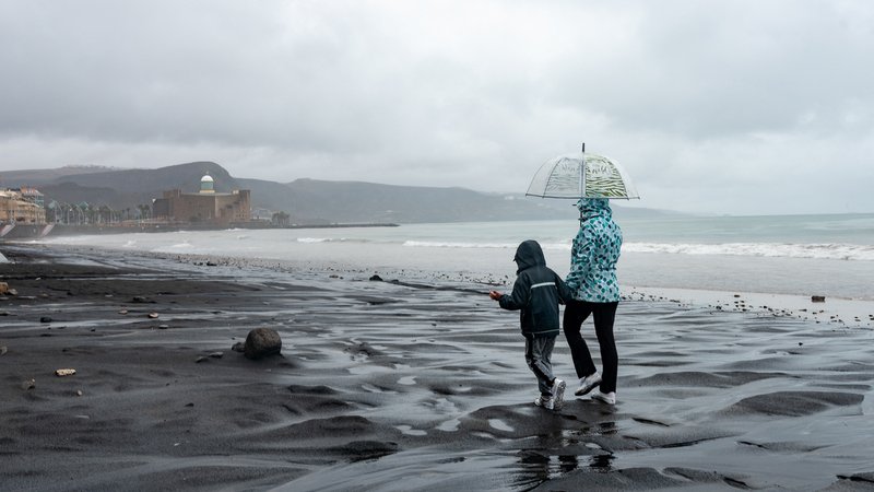 25.09.22, Las Palmas de Gran Canaria: Zwei Menschen laufen während des Tropensturms "Hermine" am Strand.