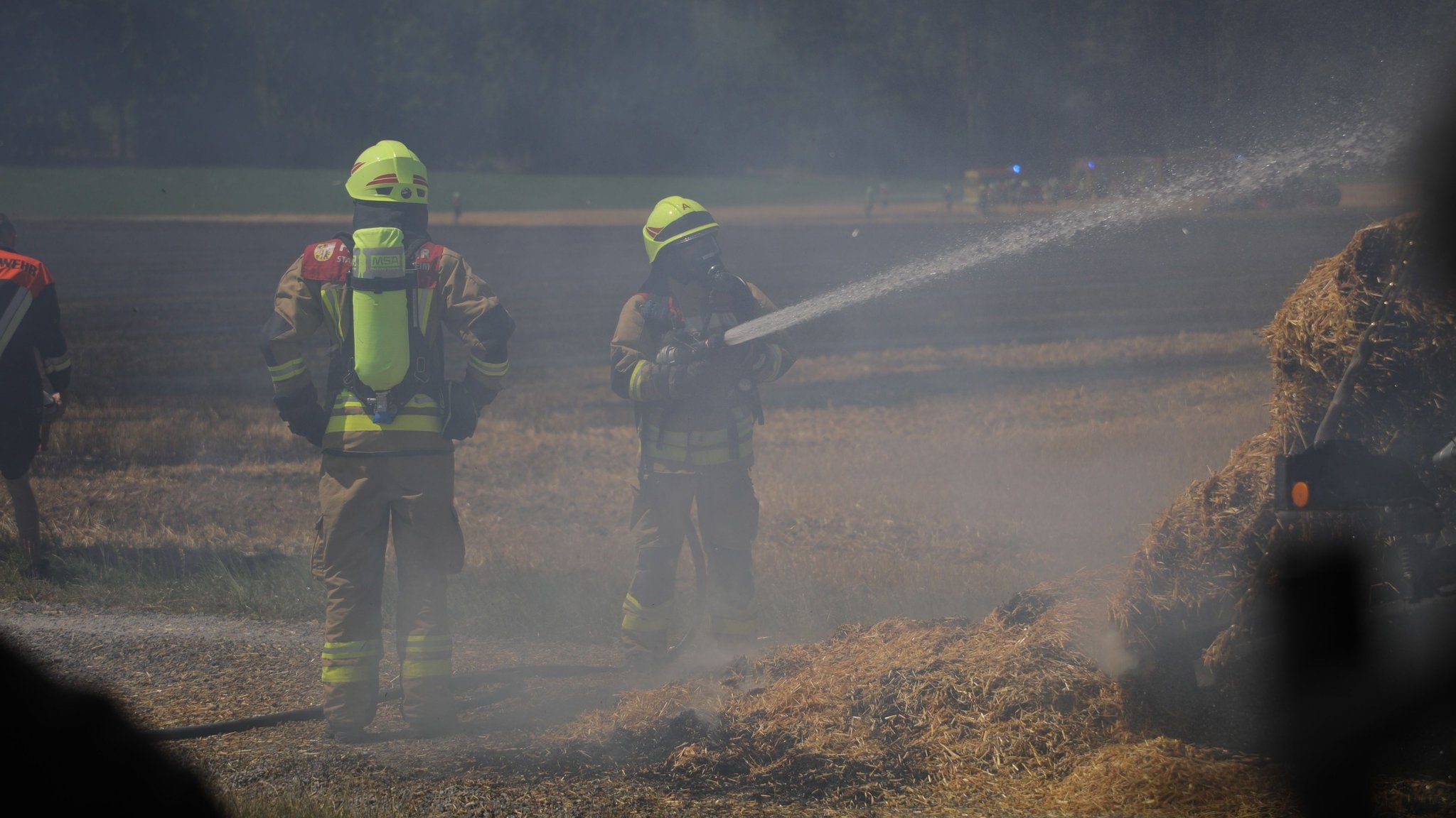 Einsatzkräfte beim Löschen auf einem Feld | Bild: NEWS5 / Markus Zahn Einsatzkräfte beim Löschen auf einem Feld