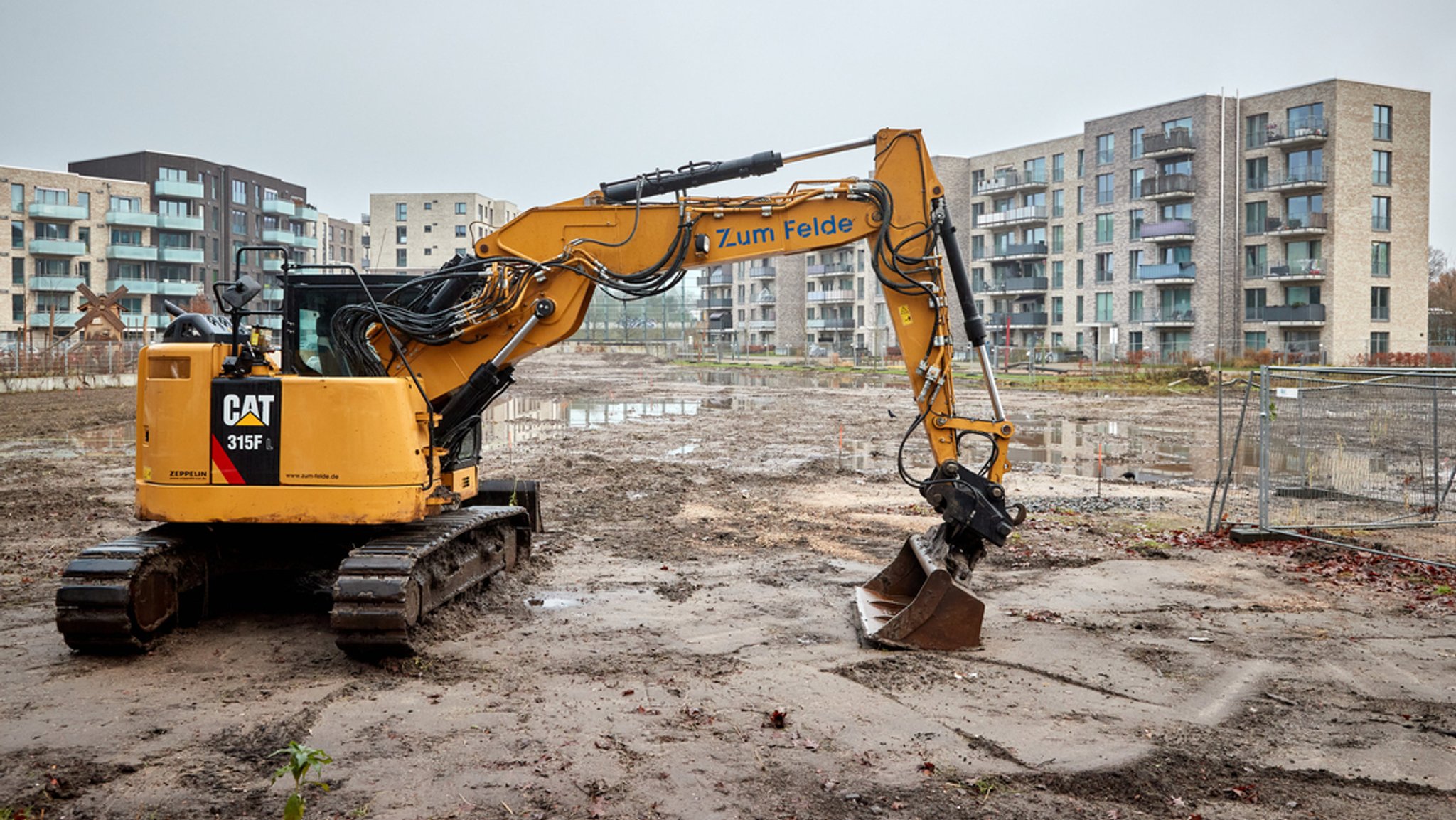 Blick auf Neubauten hinter einem Bagger auf einer Baustelle