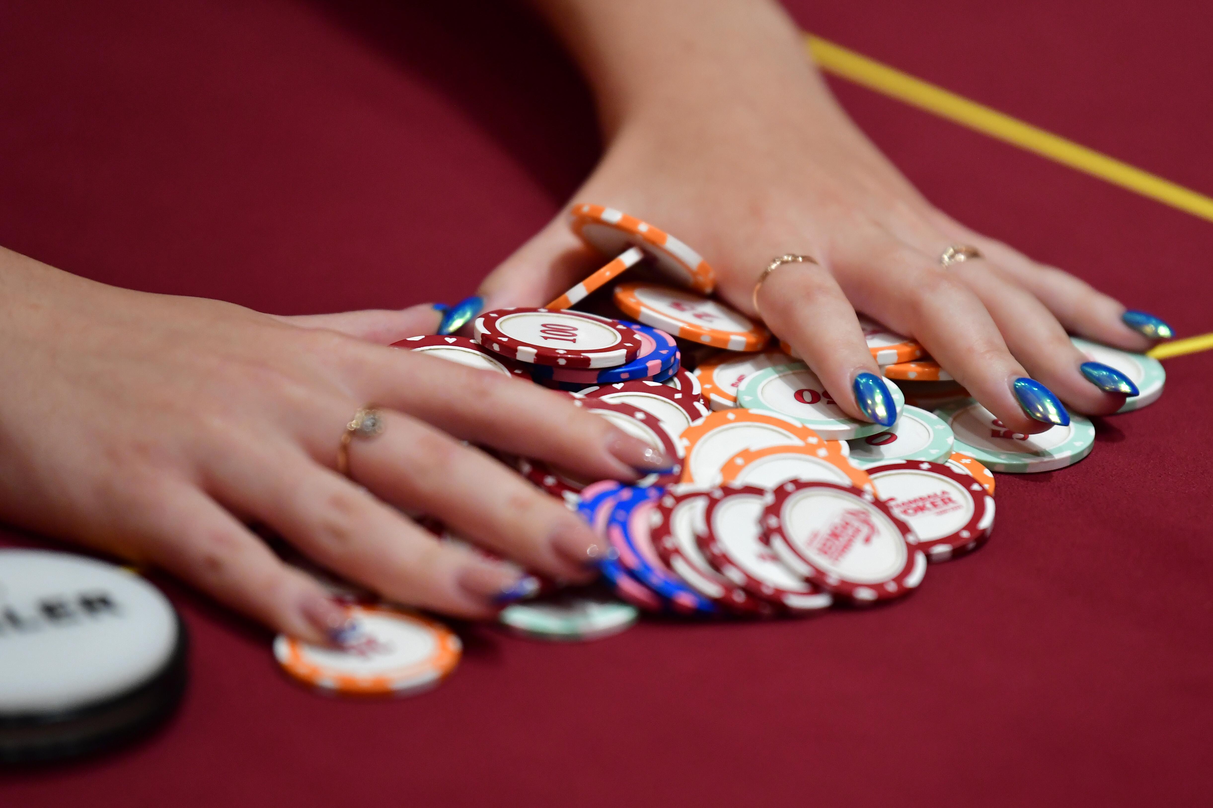 Frauenhände greifen nach bunte Spiel-Chips