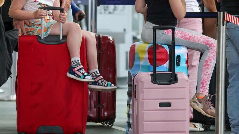 Kinder sitzen am Flughafen auf ihren Reisekoffern | Bild: dpa-Bildfunk/Jan Woitas Kinder sitzen am Flughafen auf ihren Reisekoffern