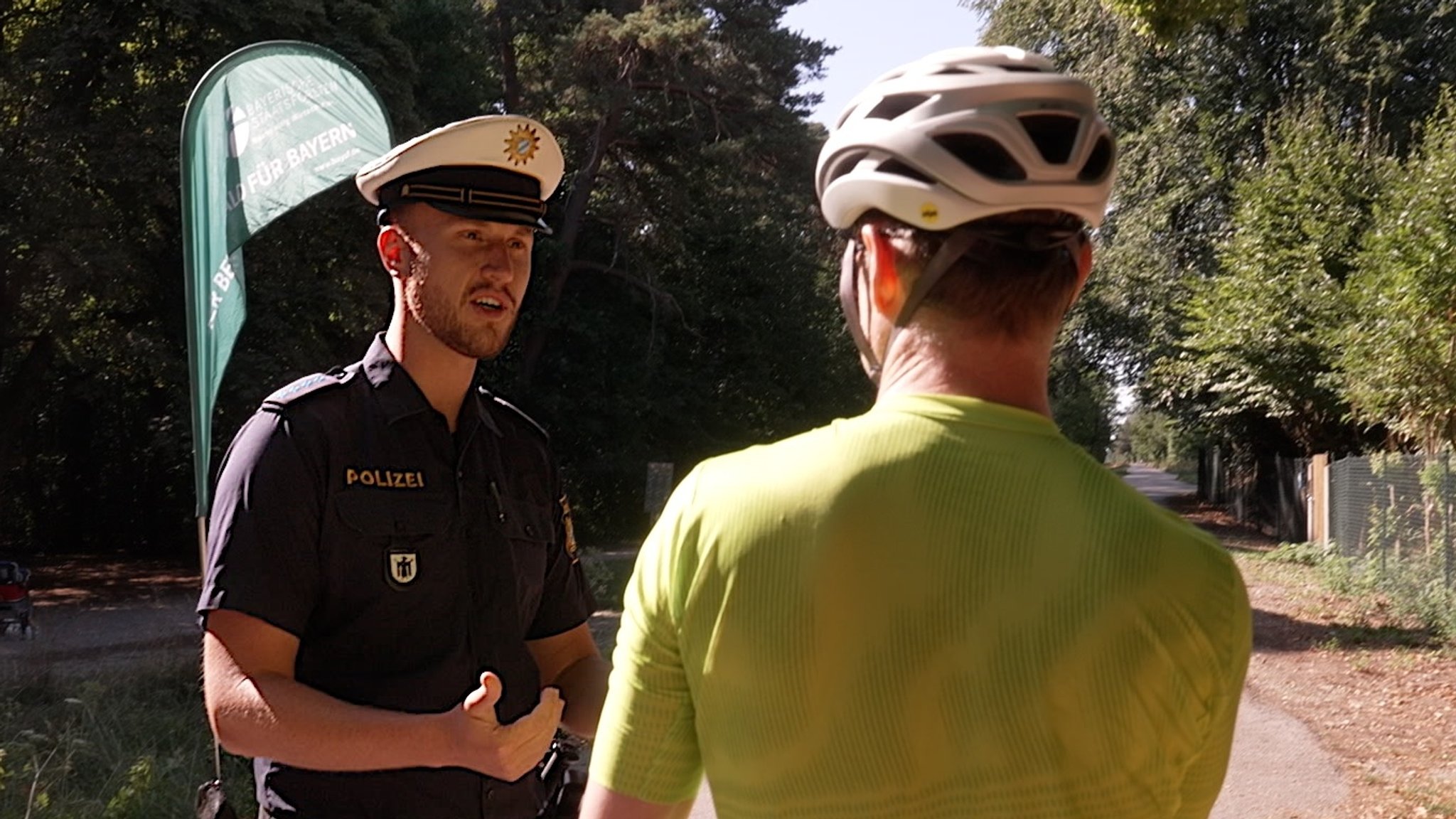 Polizist Tim Wiedecke im Gespräch mit einem Rennradfahrer | Bild: Boris Berg / BR Polizist Tim Wiedecke im Gespräch mit einem Rennradfahrer