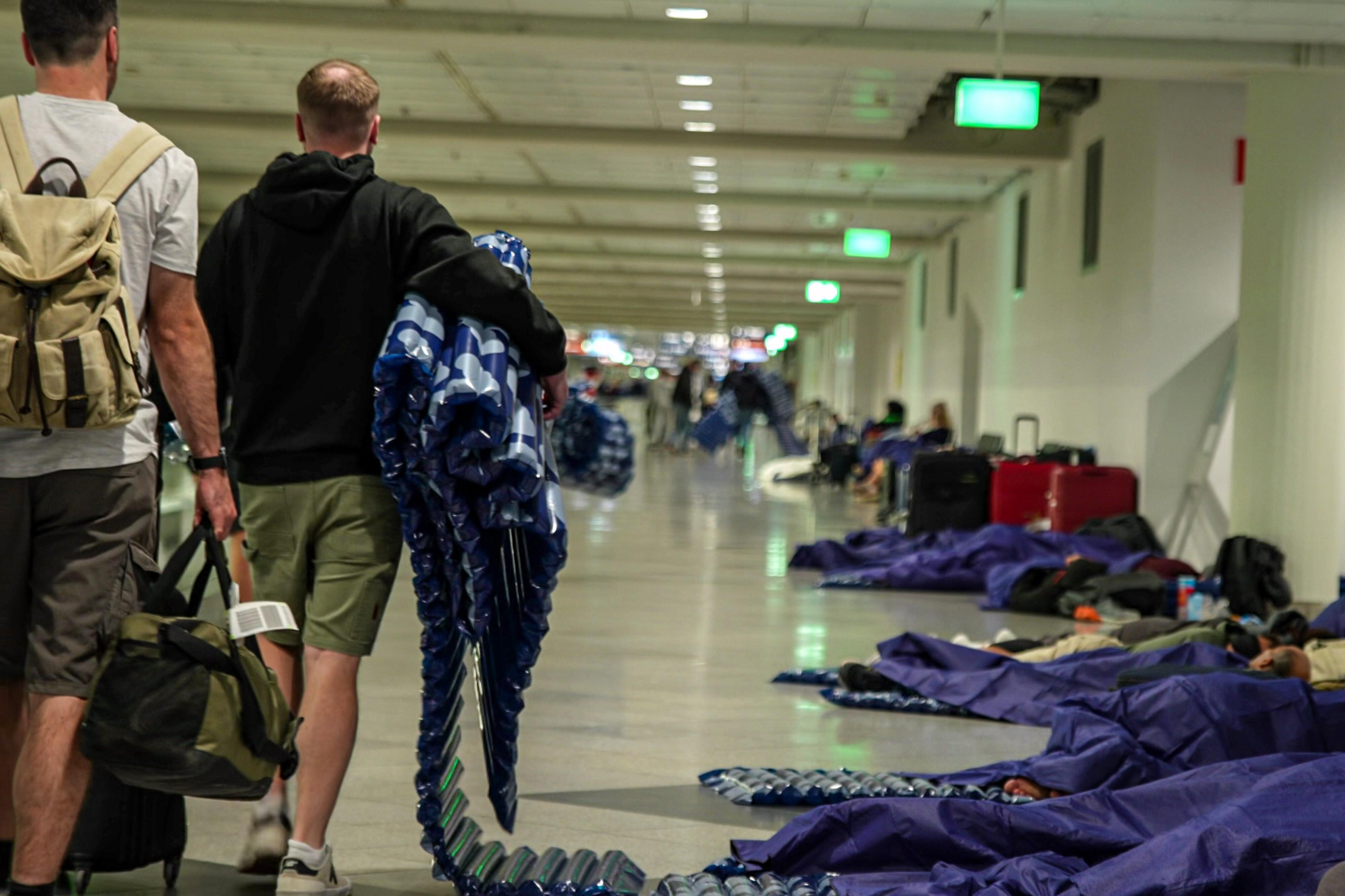 Gestrandete Reisende am Münchner Flughafen mit Luftmatratzen