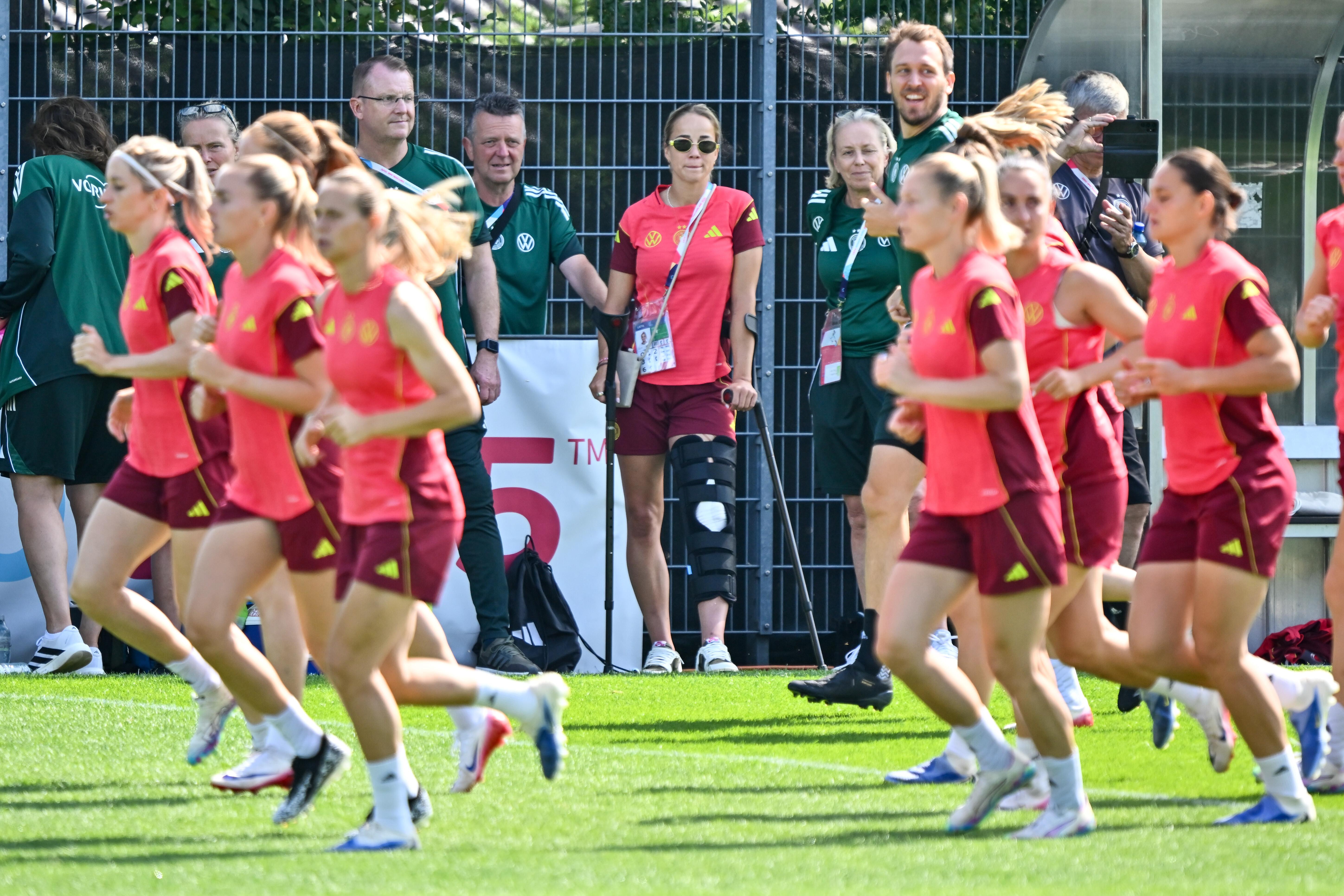  Die verletzte DFB-Kapitänin Giulia Gwinn steht am Rand und schaut dem Training zu.