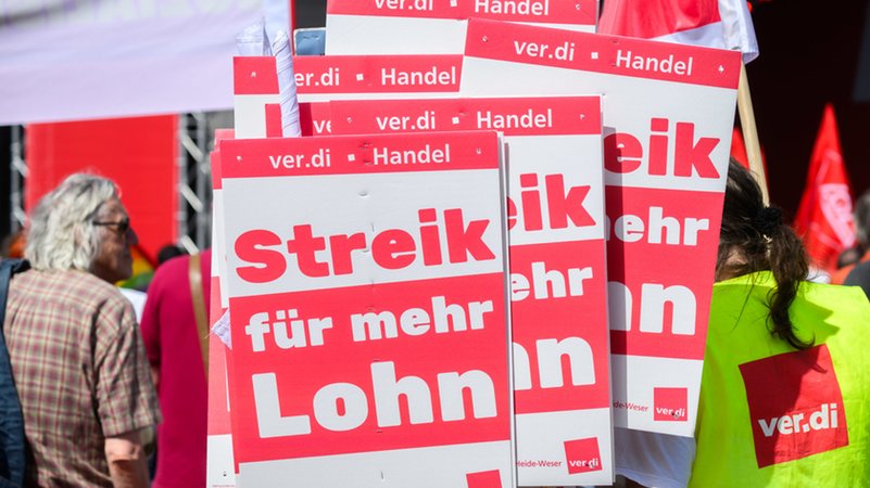 Schilder mit Aufschrift «Streik für mehr Lohn» stehen bei der Hauptkundgebung des Deutschen Gewerkschaftsbundes (DGB). | Bild: dpa-Bildfunk/Julian Stratenschulte Schilder mit Aufschrift «Streik für mehr Lohn» stehen bei der Hauptkundgebung des Deutschen Gewerkschaftsbundes (DGB).