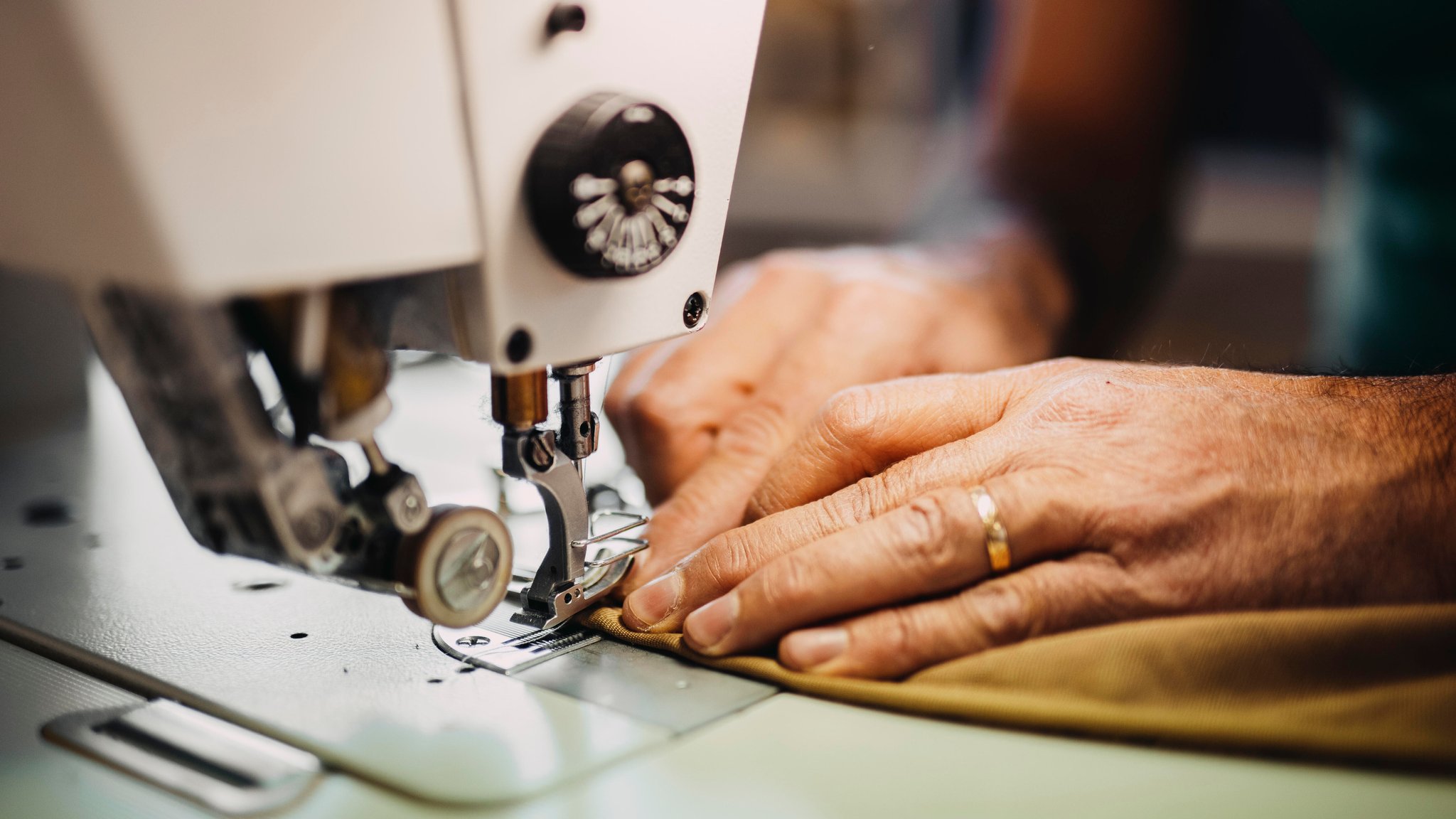 Hände an einer Nähmaschine.