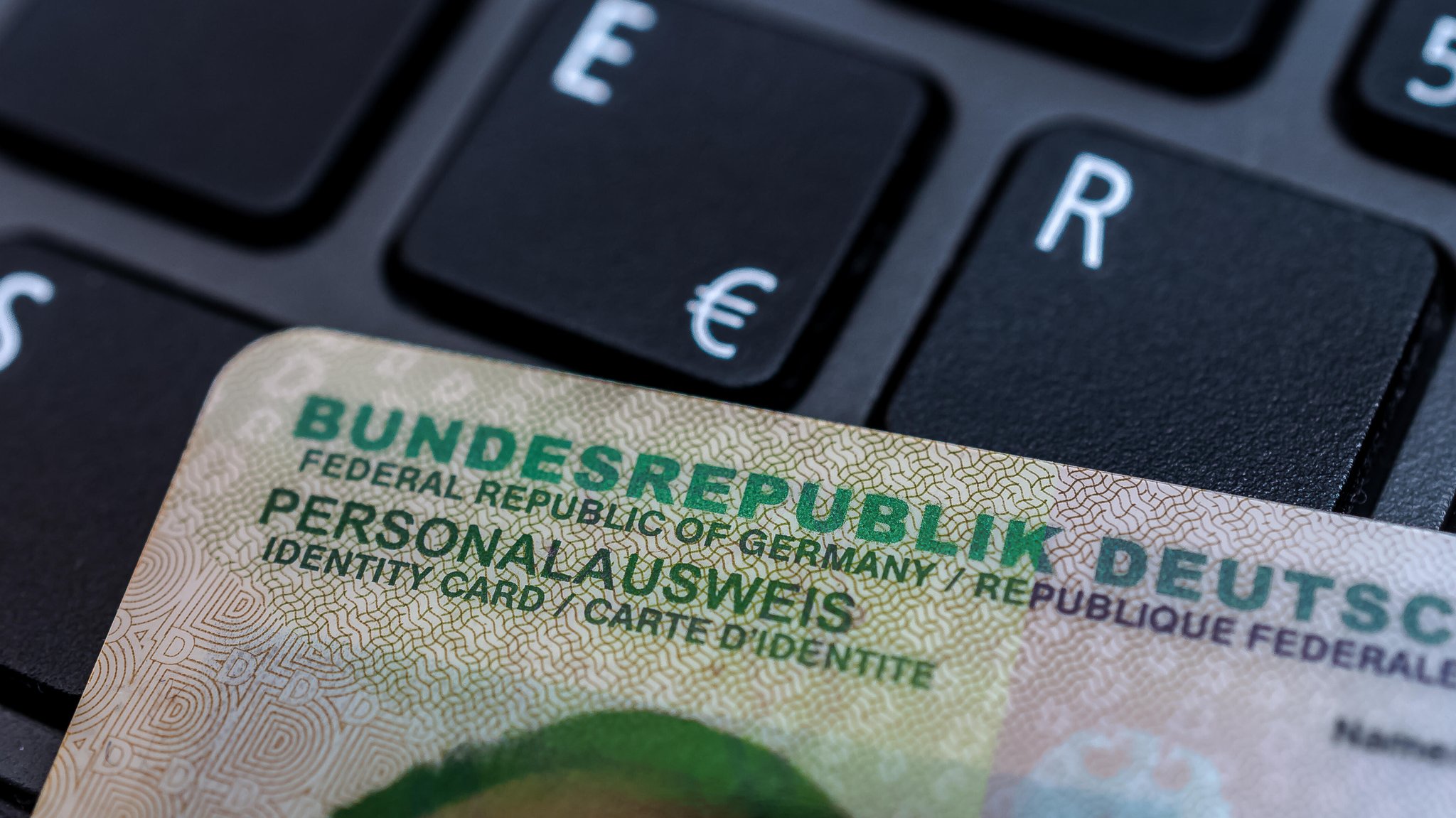Ein Personalausweis liegt auf der Tastatur eines Computers.