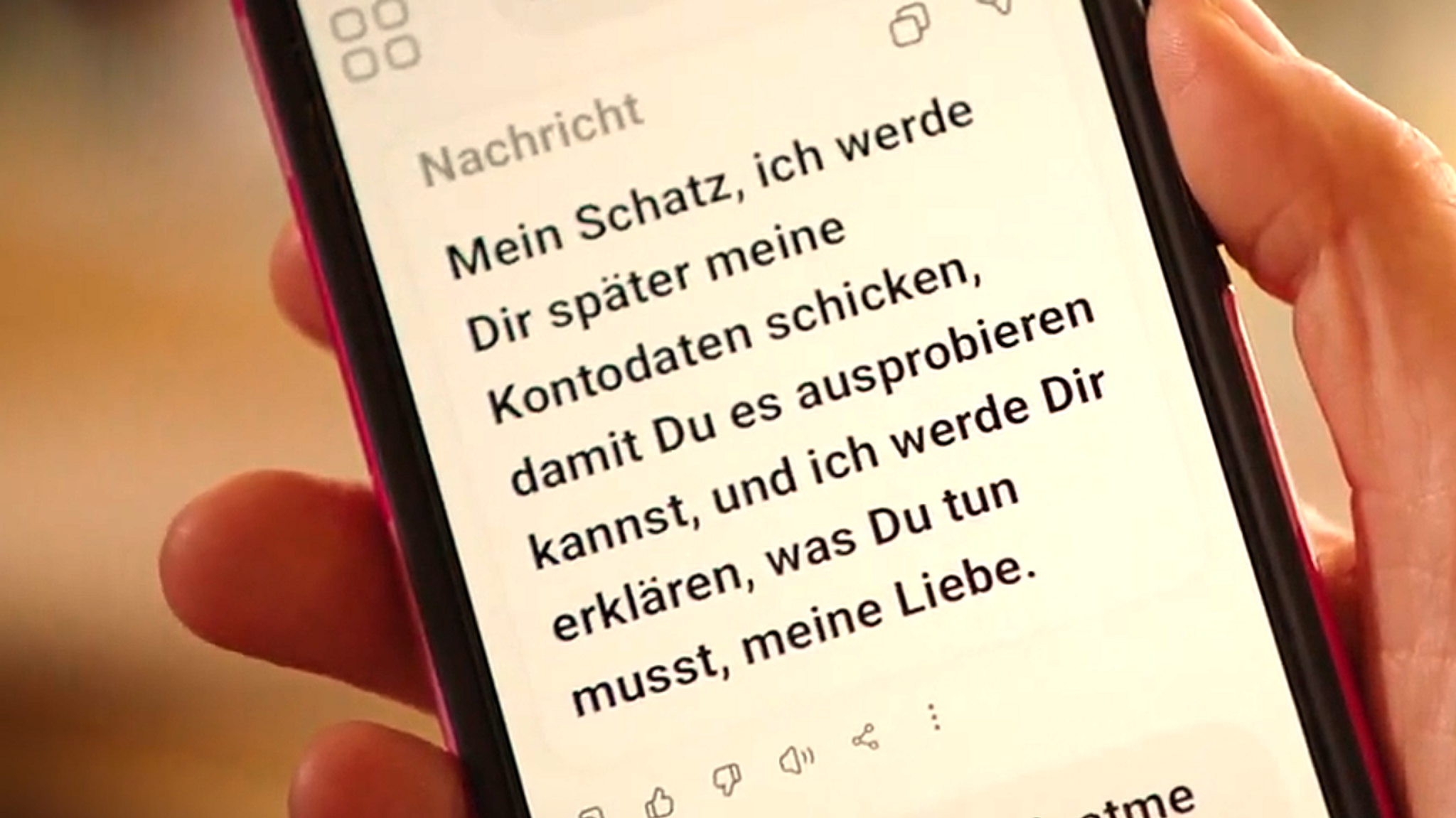 Ein Handy auf dem eine Textnachricht zu sehen ist mit dem Wortlaut: "Mein Schatz, ich werde Dir später meine Kontodaten schicken, damit Du es ausprobieren kannst, und ich werde Dir erklären, was Du tun musst, meine Liebe.