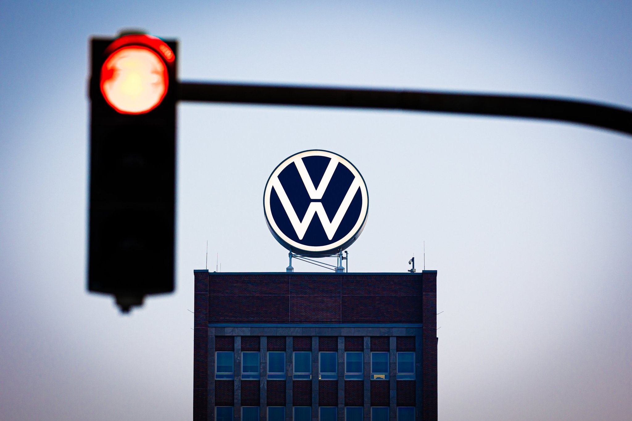 VW-Loge auf einem Hochhaus, rote Ampel