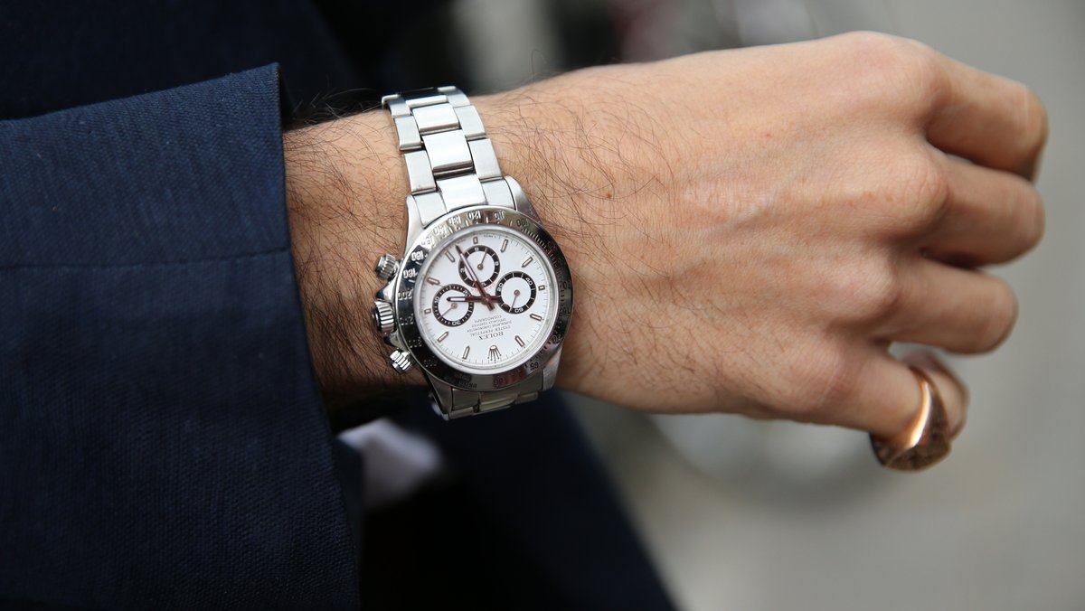Ein Mann trägt eine Rolex-Uhr.