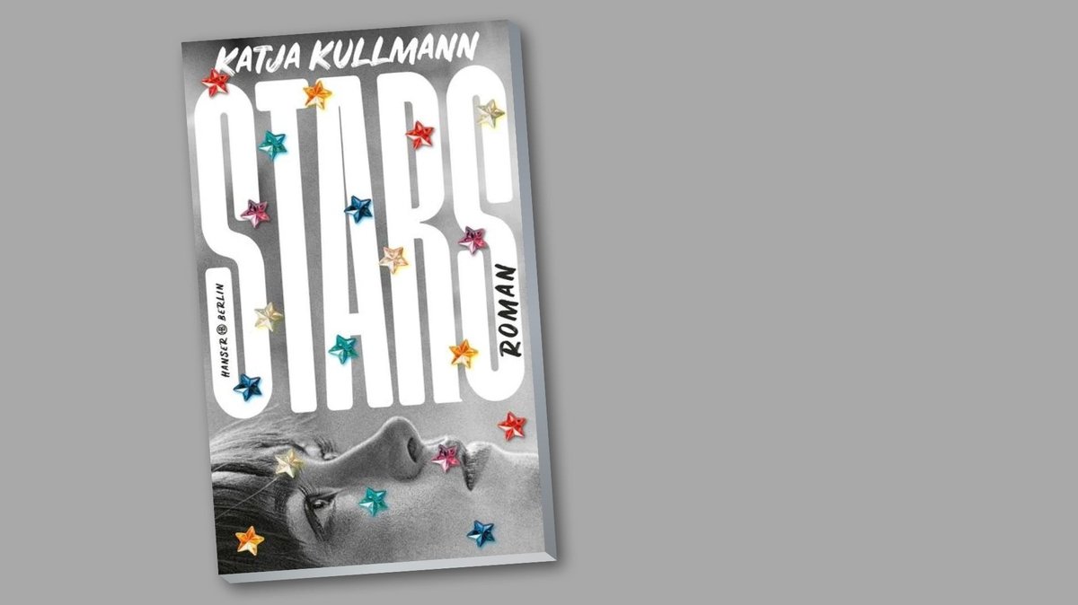 Das Buchcover von Katja Kullmanns Roman "Stars" zeigt ein schwarzweiß fotografiertes, liegendes Frauengesicht, das nach oben schaut. Über das schwarzweiße Cover sind bunte Sterne verteilt.