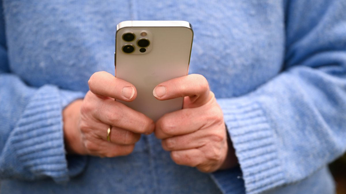Eine Frau hält ein Smartphone in den Händen.